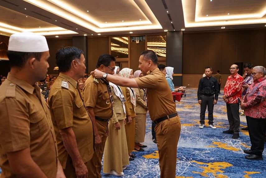PLH Kadis PMD Bolmut Rahmat Pontoh, SH, M.Si saat menyematkan kartu tanda peserta kepada kades dan aparat dihotel The Centra Manado selasa (5/9/2023) kemarin.
