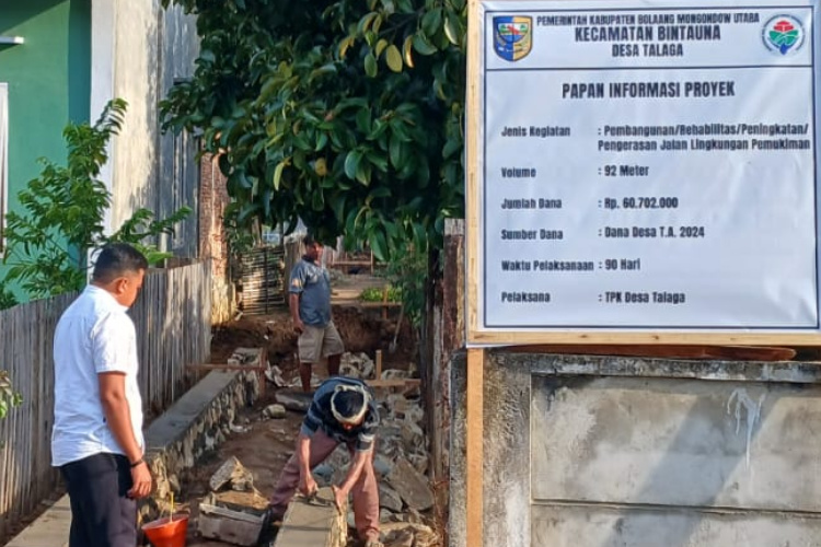 Sangadi Talaga Rahamt Djangko saat memantau pekerjaan Proyek pembangunan Rehabilitasi Peningkatan Pengerasan jalan Lingkungan pemukiman di Desa Talaga Kecamatan Bintauna dengan panjang 92 M, pagu anggaran: Rp.60.702.000 Bersumber dari angaran : DD tahun 2024.