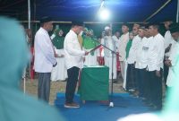 Caption Foto: Ketua Komwil Al Khairat BMR Dr. Sirajudin Lasena, SE., M.Ec.Dev, saat melantik Pengurus Cabang dan Ranting Al Khairat Kecamatan Sangkub Masa Bhakti 2025–2030 di Halaman MTS Al Khairat Sangkub 1.