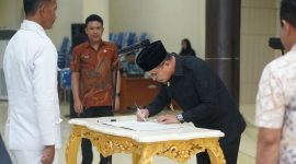 Bupati Boltara Dr. Sirajudin Lasena saat melantik Ogon Masuara sebagai Pj Sangadi Desa Wakat di Aula Kantor Bupati Bolmut.