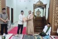 Bupati Bolmong Yusra Alhabsy menyerahkan bantuan Alquran kepada pengurus Masjid Al Muchlisin saat Safari Ramadan perdana Pemkab Bolmong di Lolak jumat (20/2/2026). 
