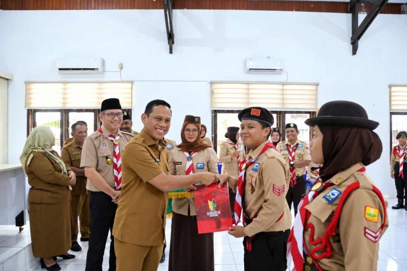 Wali Kota Kotamobagu, Weny Gaib, menyerahkan penghargaan kepada perwakilan Pramuka sebagai bentuk apresiasi atas prestasi dan partisipasi dalam Jambore Nasional (Jamnas) XII Tahun 2026.
